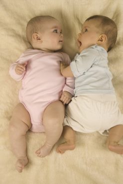 Two babies lying down together.